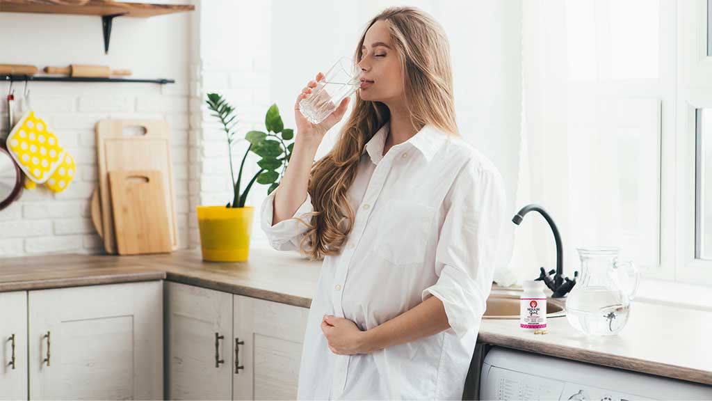 Pregnant Woman in white drinking Sunactive